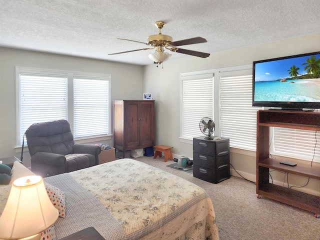 carpeted bedroom with multiple windows, a textured ceiling, and ceiling fan