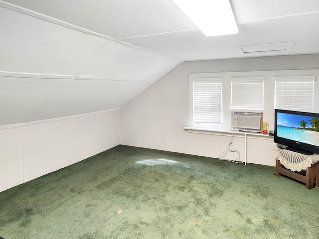 additional living space featuring dark colored carpet, cooling unit, and vaulted ceiling