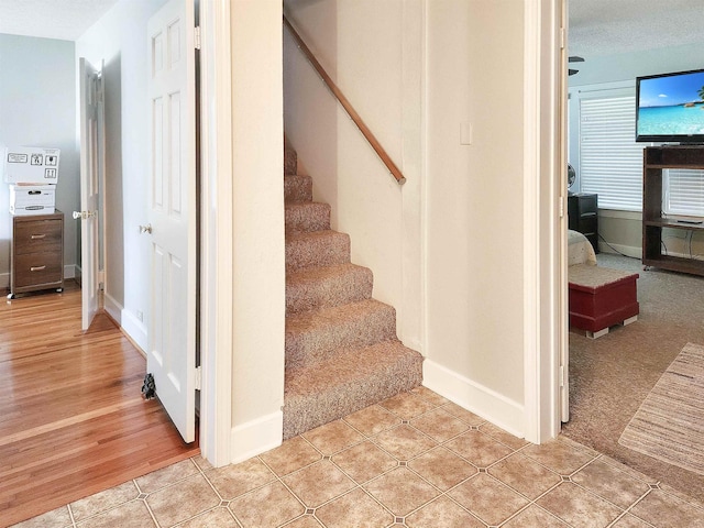 stairs featuring carpet and a textured ceiling