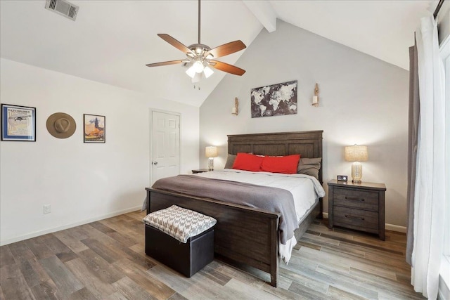 bedroom with beam ceiling, visible vents, baseboards, and wood finished floors