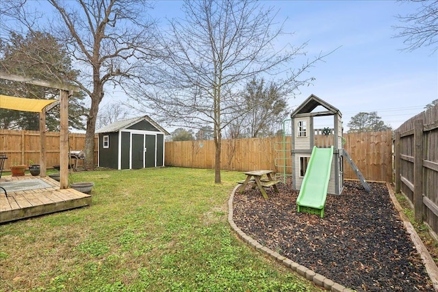 view of yard with an outbuilding, a playground, and a fenced backyard