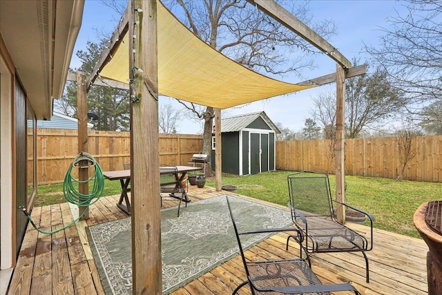 wooden terrace with a storage shed, an outdoor structure, a fenced backyard, and a lawn