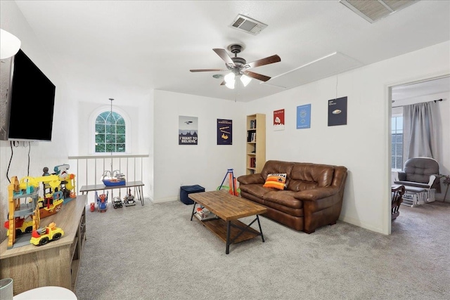 living room with plenty of natural light, attic access, ceiling fan, and carpet floors