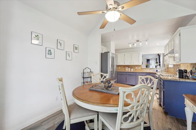 dining room featuring a ceiling fan, baseboards, and wood finished floors