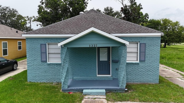 bungalow-style house featuring a front lawn