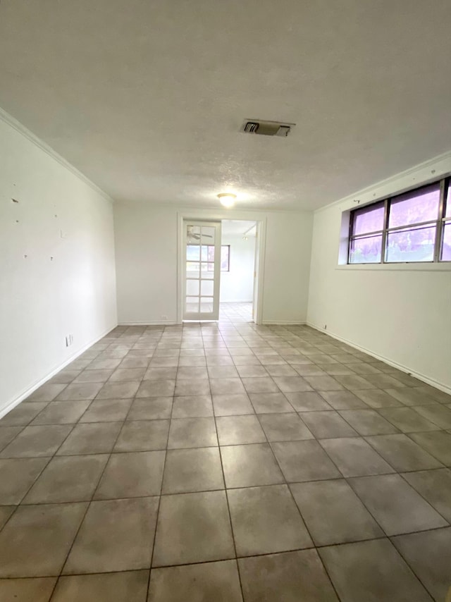 tiled spare room featuring plenty of natural light