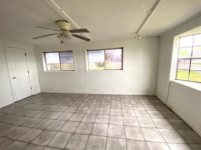 empty room featuring ceiling fan and a textured ceiling