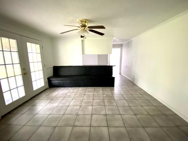 unfurnished living room with crown molding, french doors, ceiling fan, and a healthy amount of sunlight