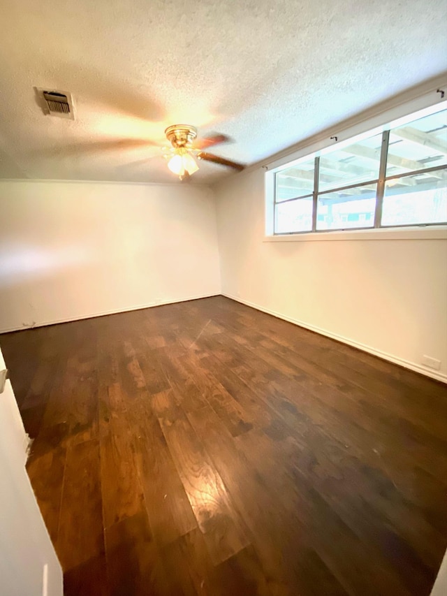 spare room featuring ceiling fan, dark hardwood / wood-style flooring, and a textured ceiling