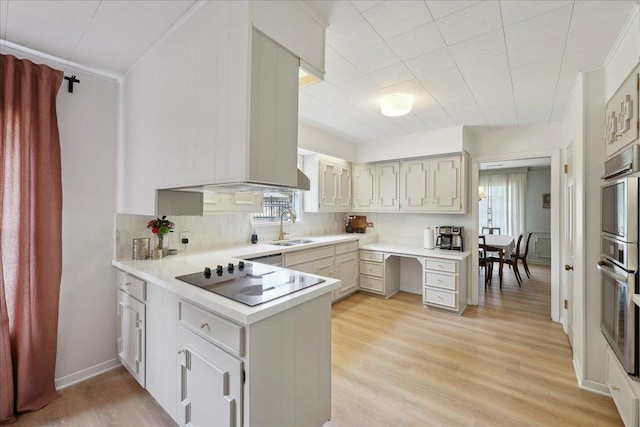1210 Nottingham Ln, Beaumont, TX 77706 - kitchen with black electric stovetop, a sink, tasteful backsplash, a peninsula, and light countertops