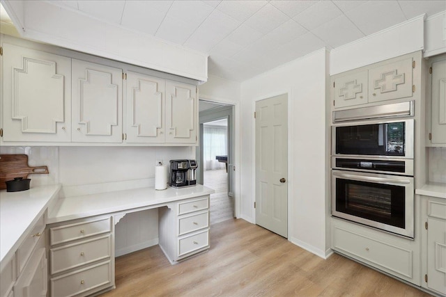 1210 Nottingham Ln, Beaumont, TX 77706 - kitchen with stainless steel oven, crown molding, light wood-style flooring, and light countertops