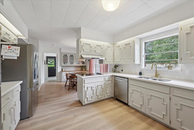 1210 Nottingham Ln, Beaumont, TX 77706 - kitchen featuring appliances with stainless steel finishes, a sink, plenty of natural light, and a peninsula