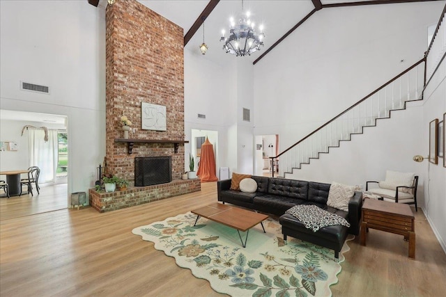 1210 Nottingham Ln, Beaumont, TX 77706 - living room with high vaulted ceiling, wood finished floors, a chandelier, stairs, and a brick fireplace