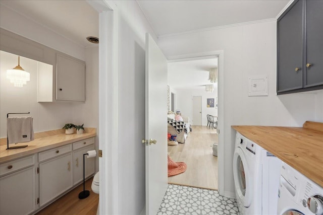 1210 Nottingham Ln, Beaumont, TX 77706 - washroom with washing machine and clothes dryer, ornamental molding, and light wood-style flooring