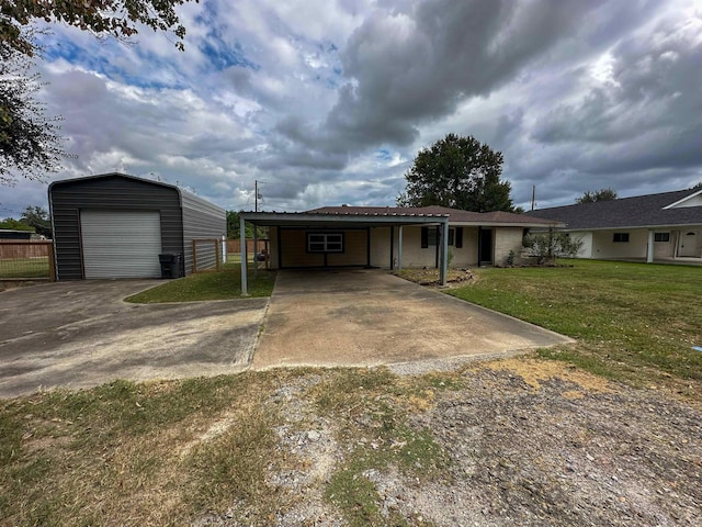 view of front of property with a carport, a garage, an outbuilding, and a front lawn