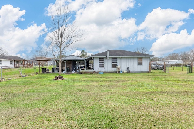 back of property featuring a yard, a fire pit, and fence