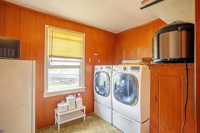 laundry area featuring laundry area, washer and dryer, and wood walls