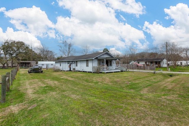 rear view of house with a yard and fence