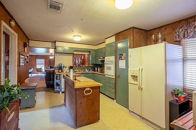 kitchen featuring visible vents, light floors, white appliances, and green cabinets