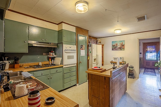 kitchen with visible vents, under cabinet range hood, white appliances, green cabinetry, and light floors