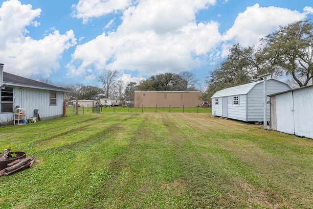 view of yard with a storage unit, an outdoor structure, and fence