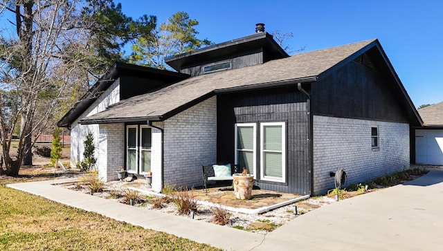 view of side of home with a garage and brick siding