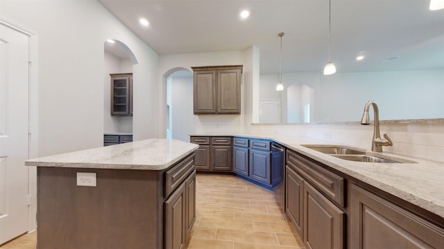 225 Sycamore Ct, Lumberton, TX 77657 - kitchen featuring arched walkways, backsplash, a kitchen island, light stone counters, and stainless steel dishwasher