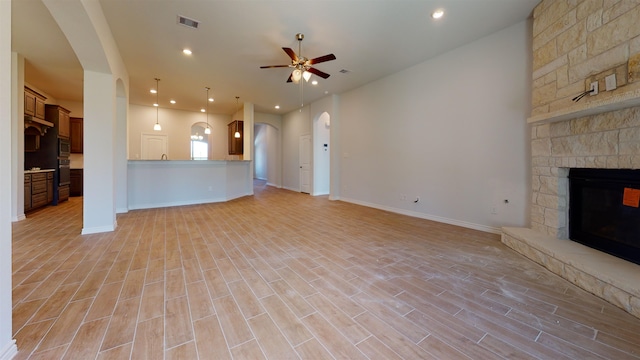 225 Sycamore Ct, Lumberton, TX 77657 - unfurnished living room with a ceiling fan, a fireplace, arched walkways, light wood-style flooring, and recessed lighting