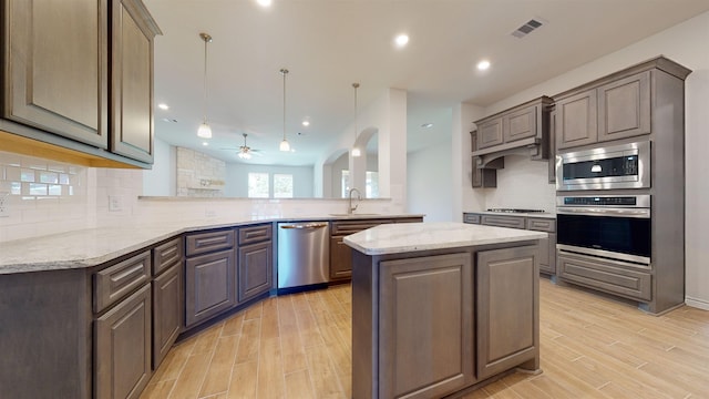 225 Sycamore Ct, Lumberton, TX 77657 - kitchen with stainless steel appliances, backsplash, ceiling fan, light wood-type flooring, and recessed lighting