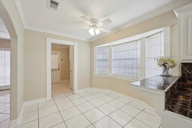 5210 Ada Ave, Beaumont, TX 77708 - dining room with ceiling fan, light tile patterned flooring, crown molding, arched walkways, and baseboards