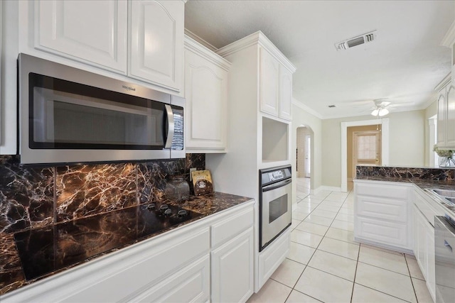 5210 Ada Ave, Beaumont, TX 77708 - kitchen featuring stainless steel appliances, dark countertops, decorative backsplash, white cabinetry, and crown molding