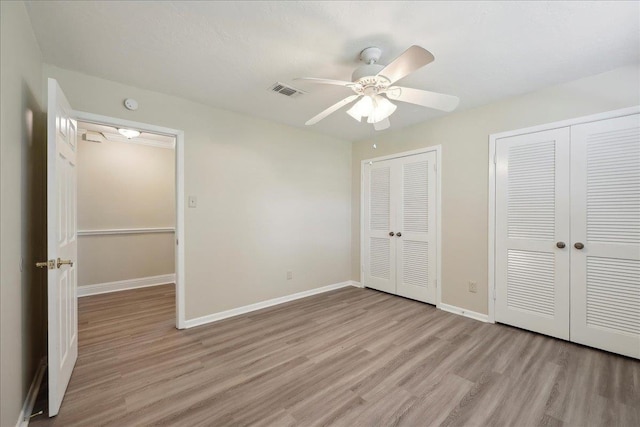 5210 Ada Ave, Beaumont, TX 77708 - unfurnished bedroom with light wood finished floors, two closets, and baseboards