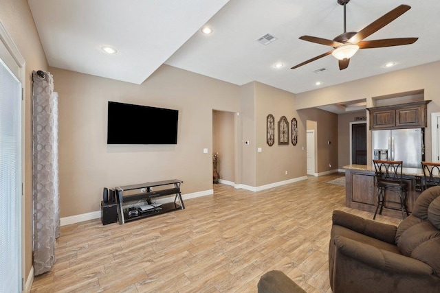 living room with ceiling fan, light wood finished floors, baseboards, and recessed lighting
