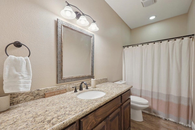 bathroom with toilet, vanity, wood finished floors, and a shower with curtain