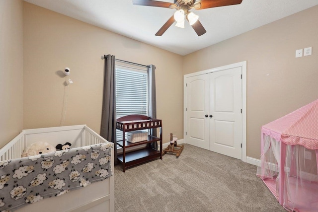 bedroom featuring light colored carpet, a closet, a ceiling fan, and baseboards