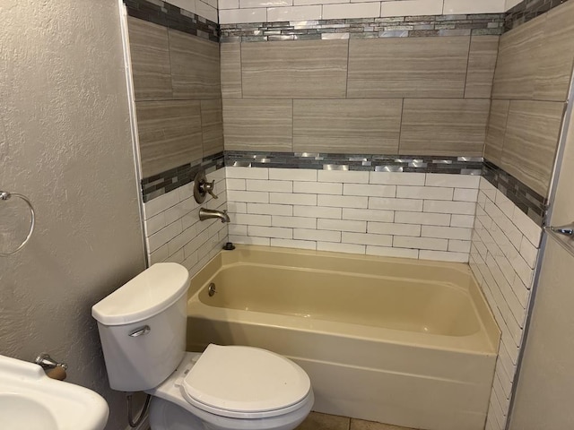 full bathroom featuring shower / tub combination, a textured wall, and toilet