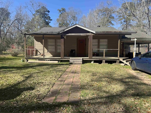 view of front of property with covered porch, a front lawn, and an attached carport