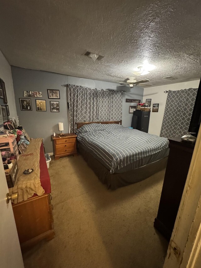 bedroom with ceiling fan, a textured ceiling, and carpet