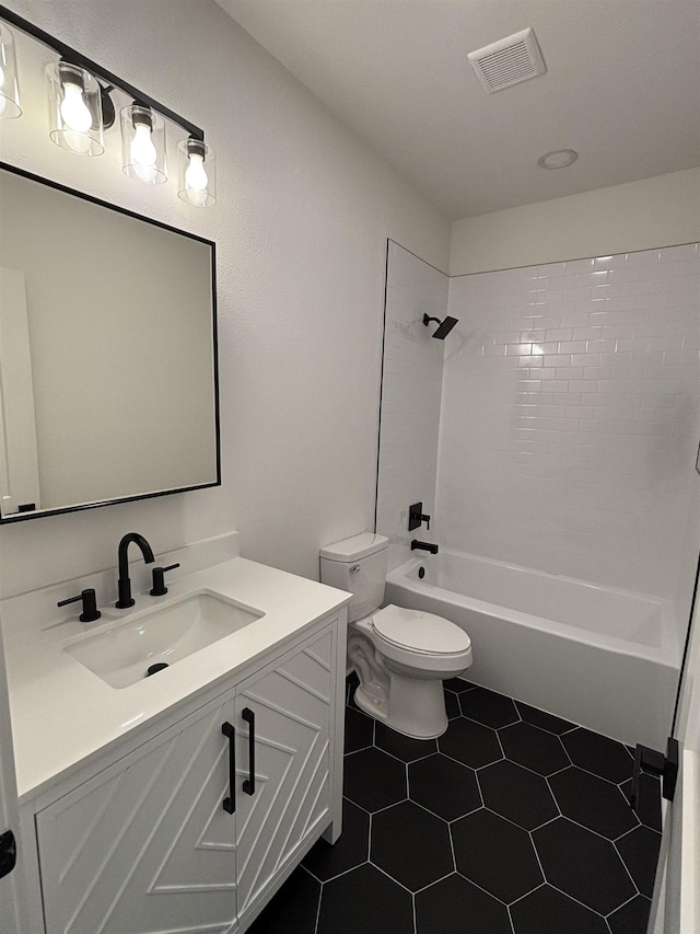 full bathroom with toilet, tile patterned flooring, tiled shower / bath, and vanity