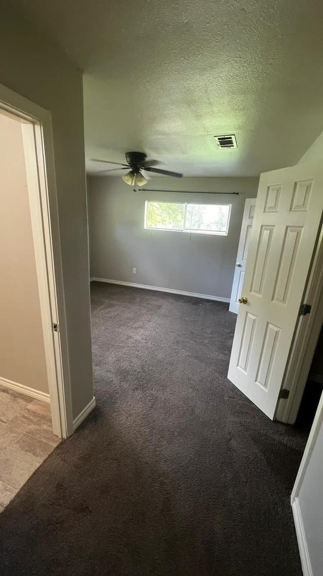 spare room featuring carpet and a textured ceiling