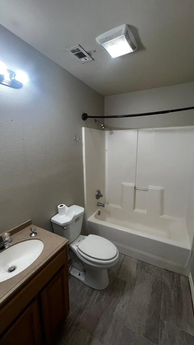 full bathroom with vanity, washtub / shower combination, and toilet