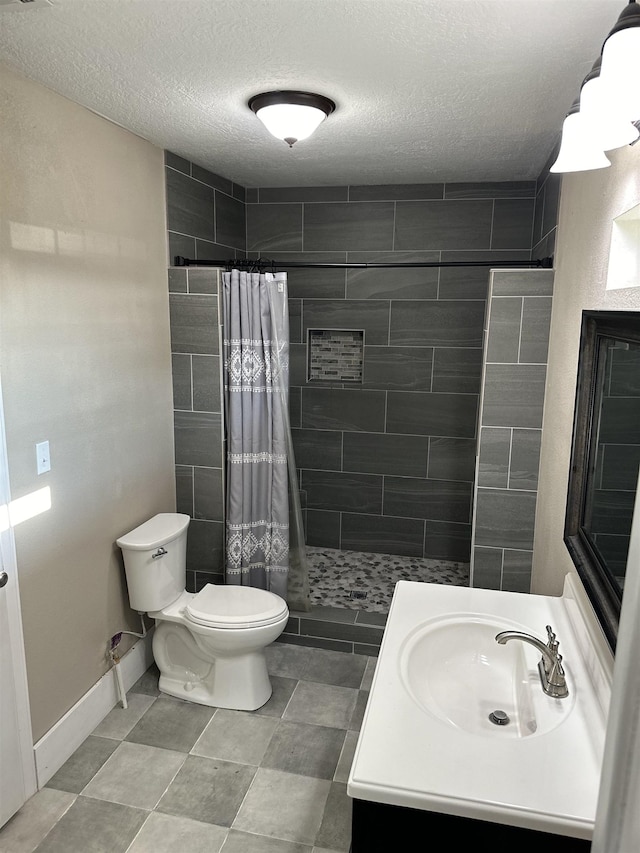 bathroom with toilet, vanity, a textured ceiling, and a shower with shower curtain