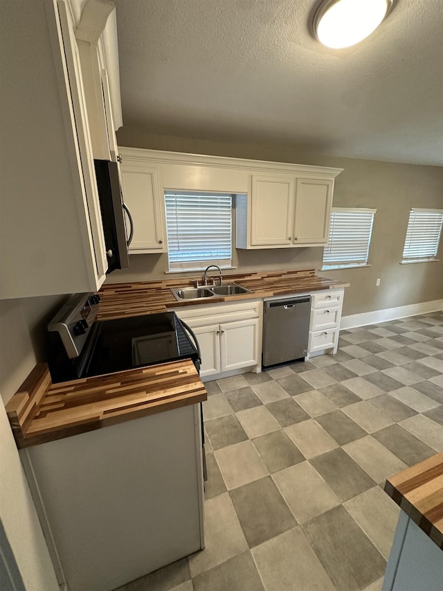 kitchen with dishwasher, white cabinets, butcher block counters, and sink