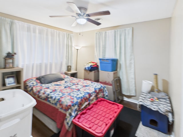 bedroom featuring visible vents, a ceiling fan, and wood finished floors