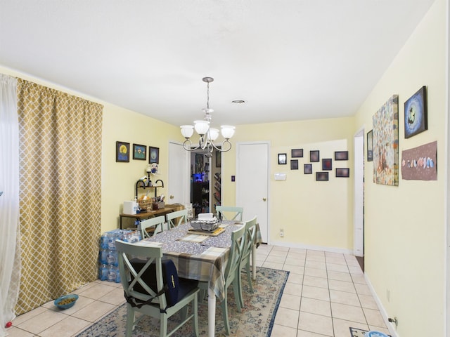 dining space featuring a chandelier, light tile patterned flooring, and baseboards