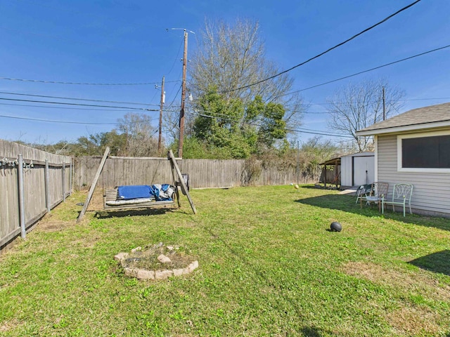 view of yard with a fenced backyard, a storage unit, and an outdoor structure