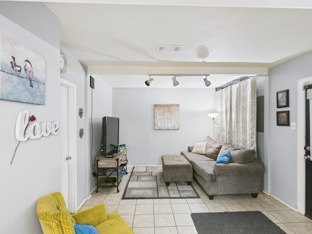 living area featuring visible vents and light tile patterned flooring