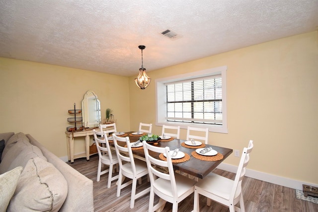 dining room featuring hardwood / wood-style floors and a textured ceiling