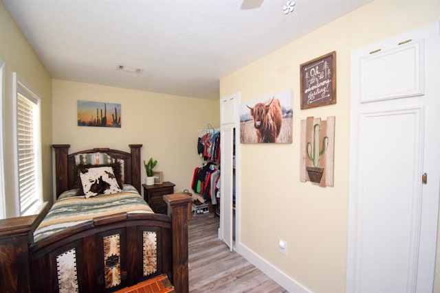 bedroom with ceiling fan, light wood-type flooring, and a closet