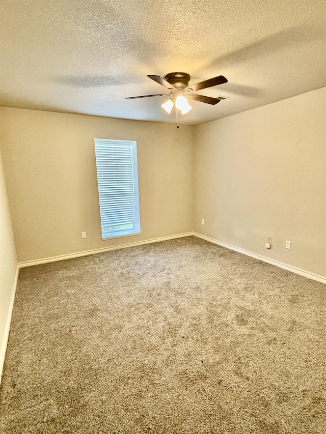 empty room with ceiling fan, carpet, and a textured ceiling